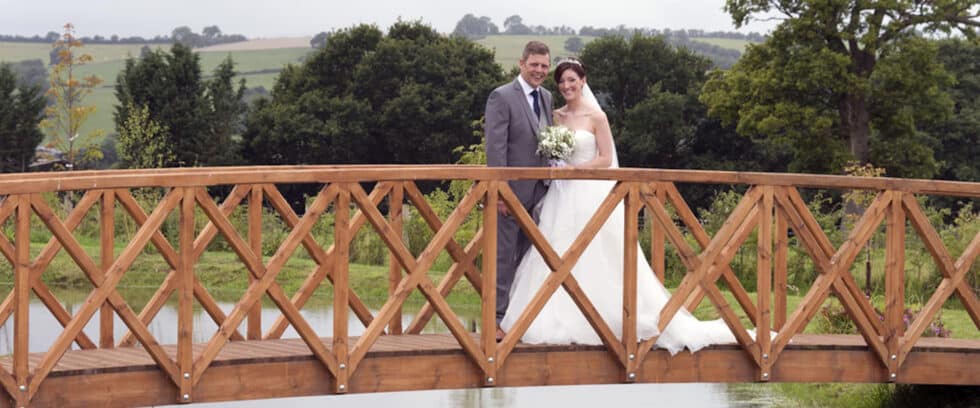 Bride & Groom on a wooden bridge.