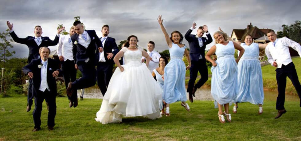 Joyful wedding party jumping together.